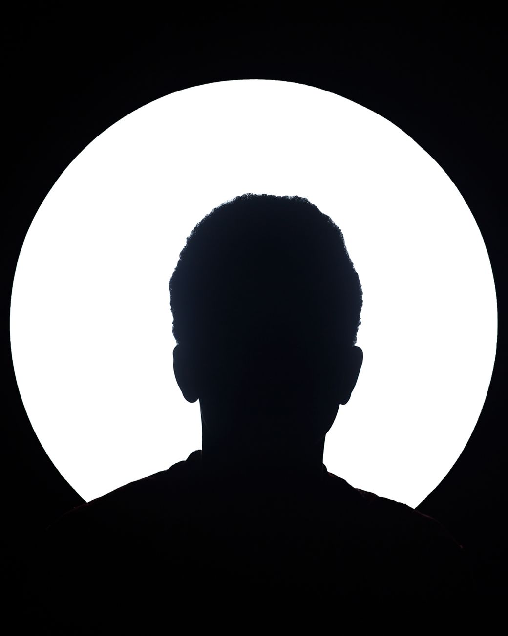 silhouette of person against white circular light