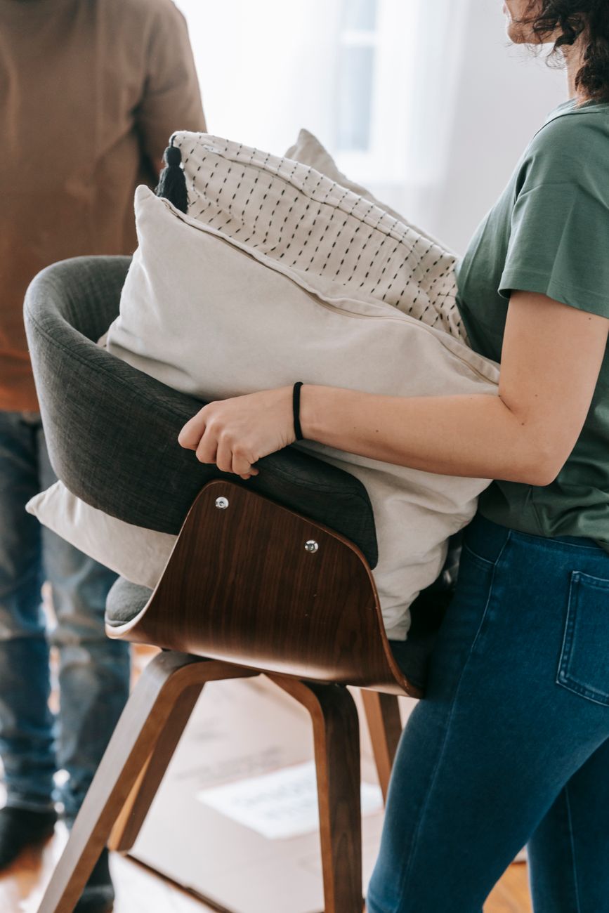 woman carrying chair with cushions